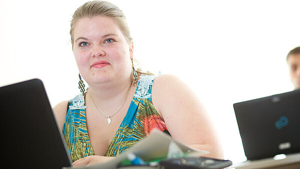 Junge Frau arbeitet am Laptop