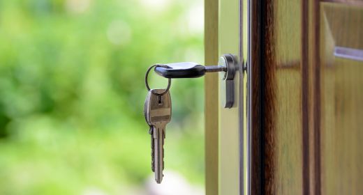 Ein Schlüssel der in einem Schloss einer geöffneten Wohnungstür steckt